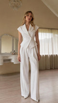 Front view of woman wearing white sleeveless blazer vest and wide-leg pants