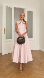 Front view of blush pink sleeveless bow neck midi dress with full A-line skirt
