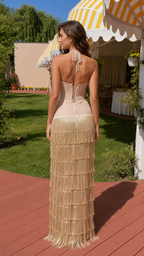 Back view of woman wearing champagne halter fringe maxi dress