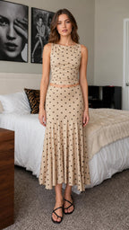 Front view of model wearing beige polka dot crop top and midi skirt set