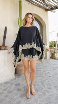 Model wearing black lace trim poncho and shorts set, front view