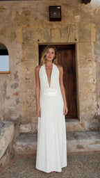 Front view of woman wearing white halter neck maxi dress
