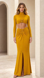 Front view of woman wearing mustard yellow mock neck crop top and ruched maxi skirt set