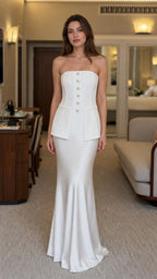 Front view of woman wearing white strapless corset peplum mermaid dress