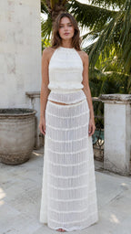 Front view of woman wearing white textured halter crop top and maxi skirt set