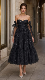 Front view of model wearing black starlight off-shoulder tulle midi dress