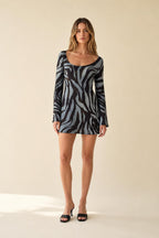 Front view of model wearing blue zebra print long sleeve mini dress
