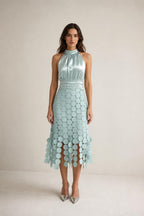Front view of sage green satin halter neck midi dress with circle fringe hem