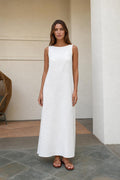 Front view of woman wearing white sleeveless maxi dress with sandals
