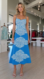 Front view of model wearing blue knit midi dress with abstract floral pattern