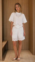Front view of model wearing white eyelet embroidered top and shorts set