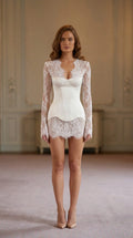 Front view of woman wearing white long-sleeve lace corset mini dress