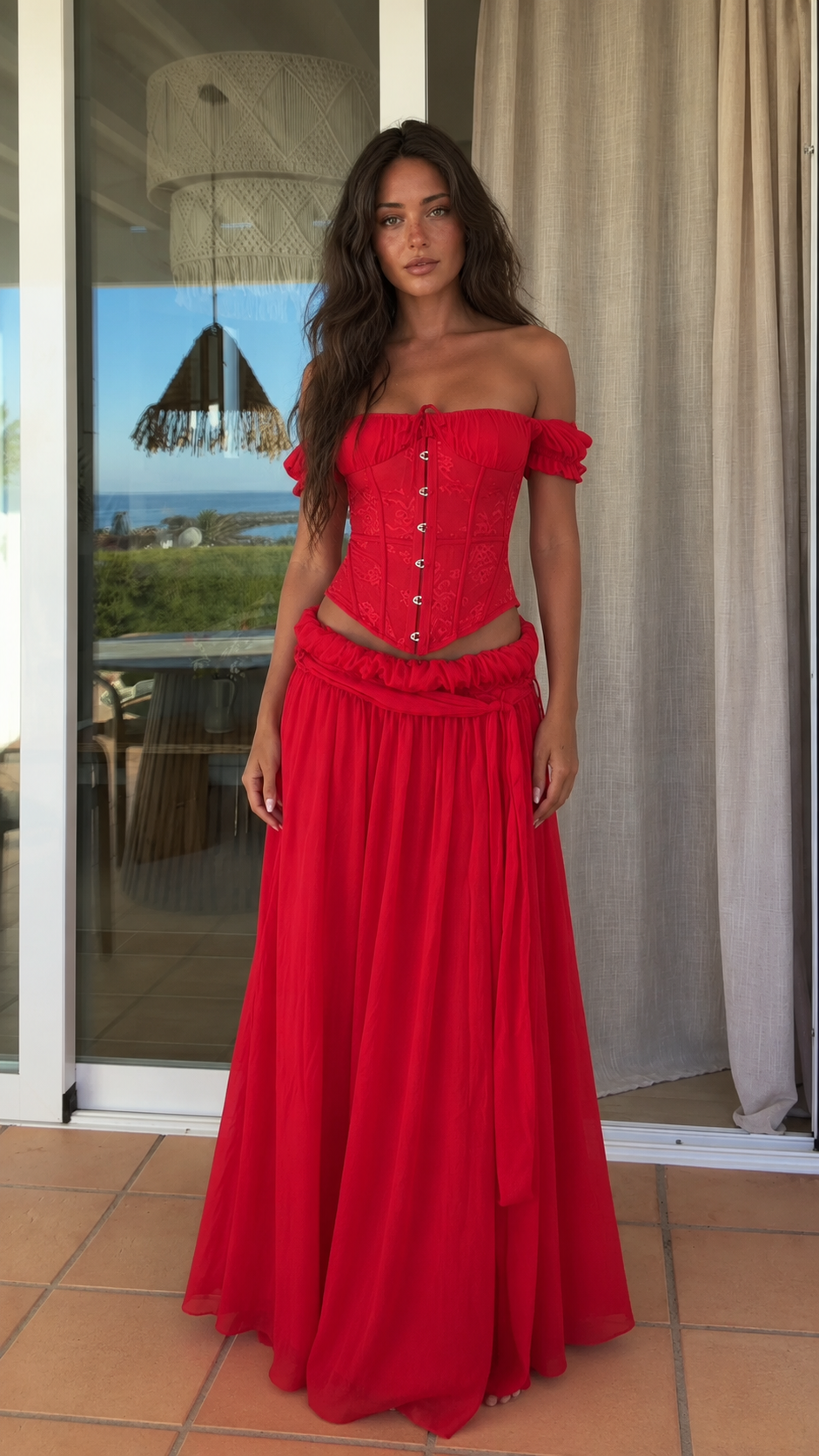 Front view of red off shoulder corset top and flowing maxi skirt set