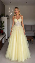 Front view of yellow halter embroidered tulle ball gown