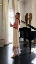 Side view of pink and cream sequin maxi slip dress with feather hem