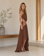 Side view of chocolate brown sleeveless maxi dress with waist cutout and flowing hem