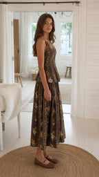 Side profile of model in brown floral two-piece set with woven flats