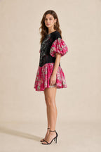 Side profile view of model in black graphic mini dress