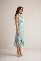 Side profile view of sage green satin halter midi dress