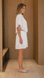 Side view of model wearing white eyelet embroidered set