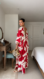 Side view of red tropical print caftan maxi dress showing open back detail