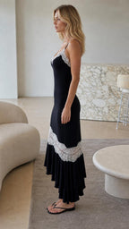 Side profile of model wearing the black lace-trim slip midi dress