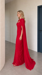 Side profile view of red cape evening gown