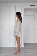 Side view of model wearing grey off-the-shoulder chiffon mini dress