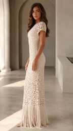 Side view of cream textured crochet-look maxi dress with slim silhouette and fringe hem