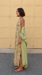 Side profile of model in olive floral maxi dress showing side slit