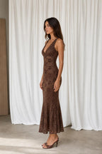 Side profile view of model in brown lace midi dress