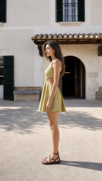 Model wearing olive green cutout smocked mini dress, side view