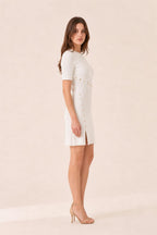Side profile of woman in white ribbed knit mini dress