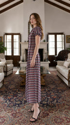 Side profile view of model in multi-stripe maxi dress