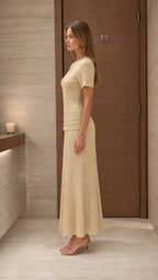 Model wearing beige knit two-piece set from the side profile