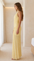 Side profile view of yellow one-shoulder pleated maxi dress