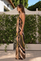 Side profile of woman in olive geometric halter maxi dress