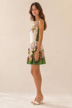 Side profile view of model in beige floral mini dress