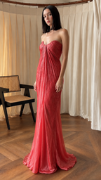 Angled front view of rose red strapless pleated floor-length gown