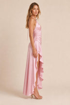 Model wearing pink satin halter dress showing side profile and high-low hem