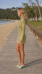 Side profile view of Sage Green knit mini dress on model