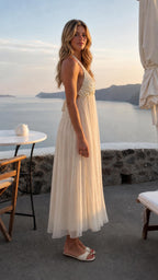 Side profile of woman wearing ivory sequin halter neck maxi dress