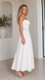 Side view of white pleated maxi dress with slim straps and tiered skirt