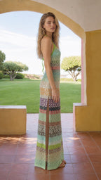 Model wearing Multi Green striped sequin halter maxi dress, side view with slit