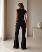 Back view of the black matching set with fitted cap-sleeve top and fringe flare pants