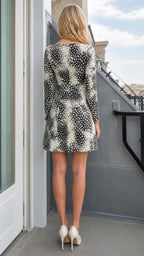 Model wearing black abstract print cutout mini dress from the back