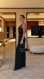 Side view of black elegant wide leg jumpsuit with sleeveless cut and fluid bodice