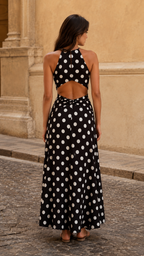 Back view of black polka dot halter maxi dress with open back cutout detail