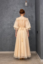 Back view of model in cream maxi dress showing back tie detail