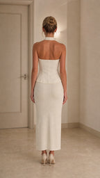 Back view of model wearing ivory halter top and midi skirt